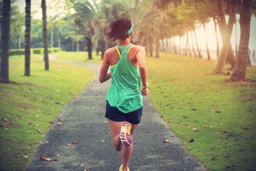 Eine Frau joggt im Park und trainiert für einen Marathonlauf. 