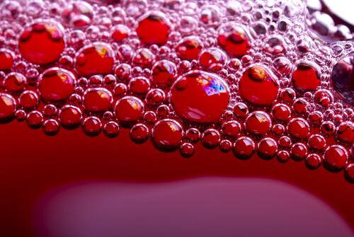 Nahaufnahme von Blubberbläschen in einer roten Limonade