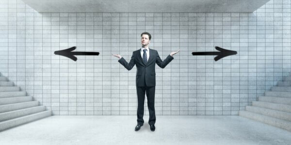 Ein Mann steht an einem Scheideweg und fragt sich, welche Richtung er einschlagen soll.