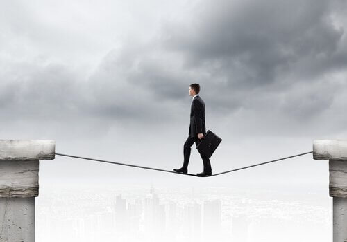 Mann balanciert zuversichtlich auf einem Drahtseil