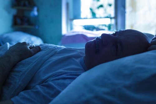Mann, der im Bett liegt und sich Sorgen macht