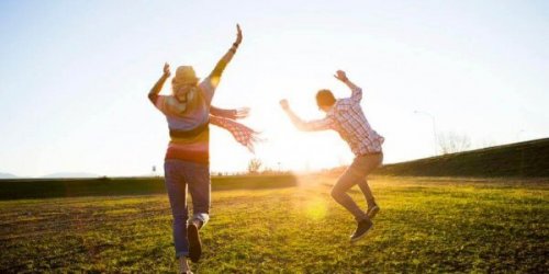 Paar springt durchs Feld