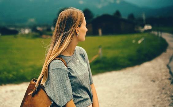Frau schaut einen Weg zurück