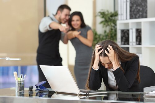 Eine Frau wird von ihren toxischen Kollegen gemobbt.