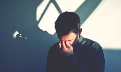 Trauriger Mann mit Hand vor Gesicht