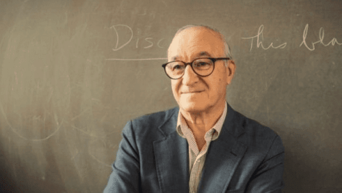 Albert Bandura vor einer Tafel stehend