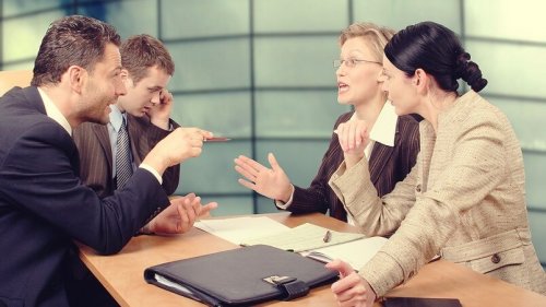 Eine Gruppe von Arbeitnehmern in einem hitzigen Gespräch