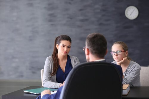 Eine Mutter und ihre Tochter sind in einem Gespräch mit dem Lehrer.