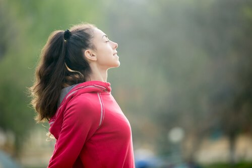 Frau, die nach dem Sport tief einatmet