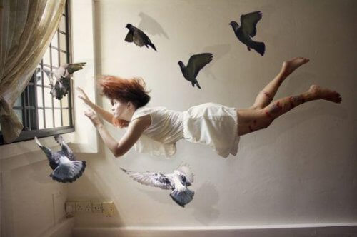 Eine Frau schwebt umgeben von Tauben mitten im Raum.