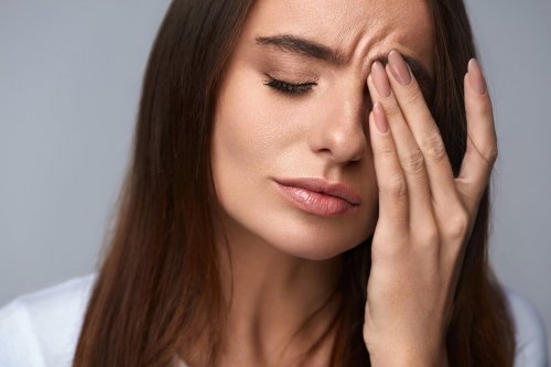 Eine Frau reibt sich besorgt die Augen.