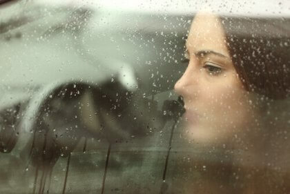Eine Frau schaut durch ein beschlagenes Fenster.