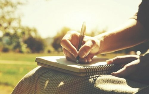 Eine Frau schreibt in ihr Notizbuch.