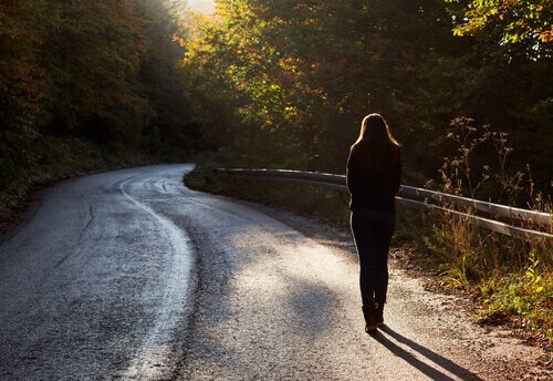 Frau spaziert allein auf einer Straße