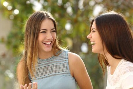 Zwei Freundinnen unterhalten sich und lachen.