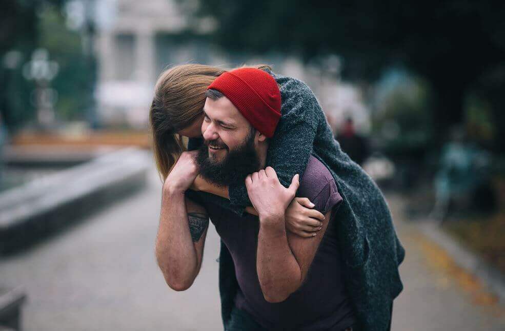 Frau umarmt ihren Freund glücklich von hinten