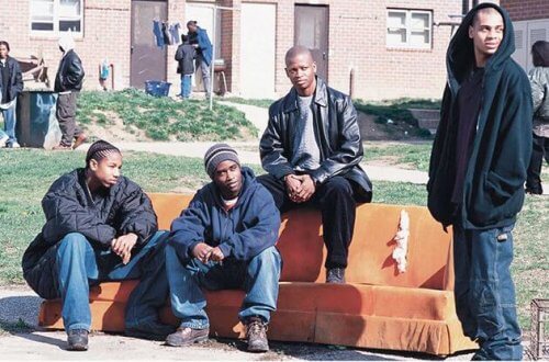 Eine jugendliche Gang, die in Baltimore auf einer Couch vor einem Haus sitzt 