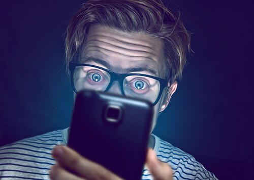 Technopathologie - junger Mann start auf sein Handy
