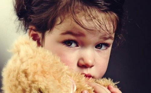 Ein Kind hält einen Teddybären.