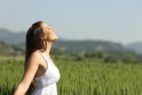 Eine Frau steht auf einem Feld und lächelt.