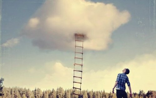 Ein Mann steht vor einer Leiter, die in einer Wolke verschwindet.