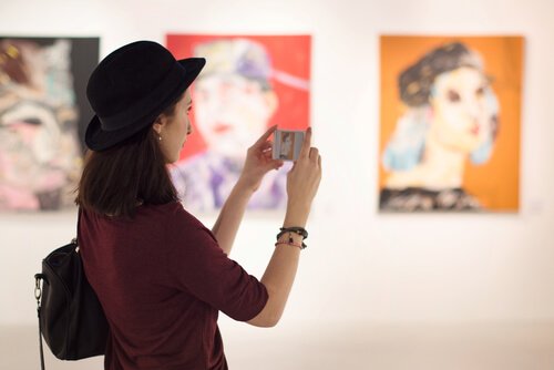 Eine Besucherin im Museum macht Fotos von Kunstwerken.