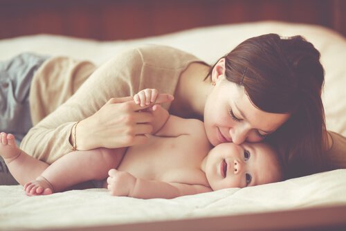 Eine junge Mutter umarmt glücklich ihr Baby.