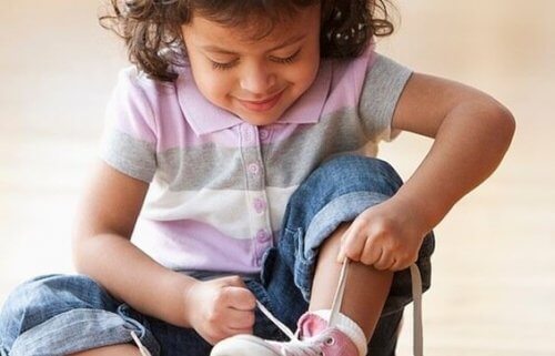 Selbstständiges Kind bindet sich die Schuhe.