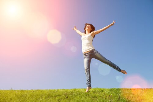 Eine Frau hüpft und genießt den Sonnenschein.