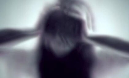 Verschwommenes Bild einer Frau, die ihre Hände an den Kopf hält