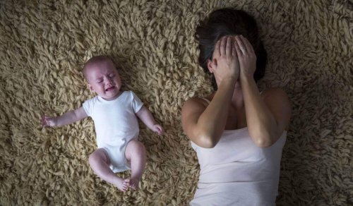 Frau, die auf dem Boden nahe bei ihrem schreienden Baby liegt
