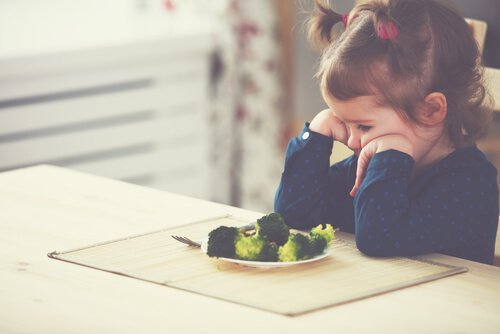 Ein kleines Mädchen will kein Gemüse essen.