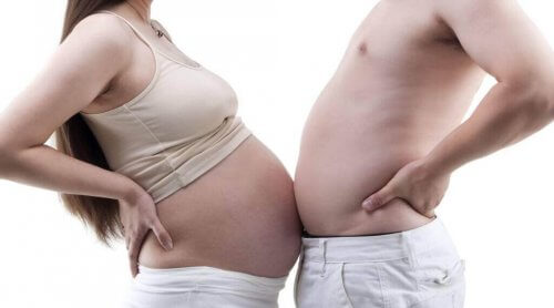 Eine Schwangere vergleicht ihren Babybauch mit dem Bauch eines Mannes. 