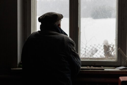 Mann mit Morbus Alzheimer, der aus dem Fenster blickt