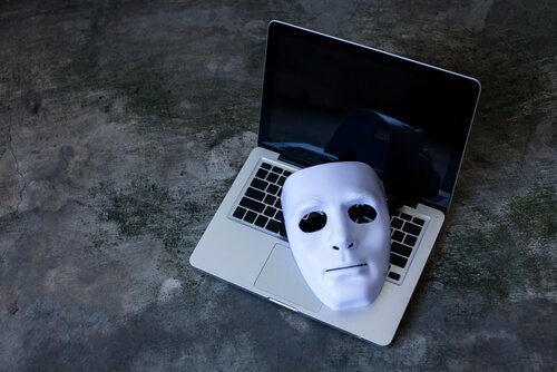 Eine Phantommaske liegt auf der Tastatur eines Laptops.