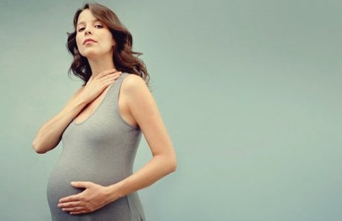 Eine schwangere Frau präsentiert stolz ihren Babybauch. 
