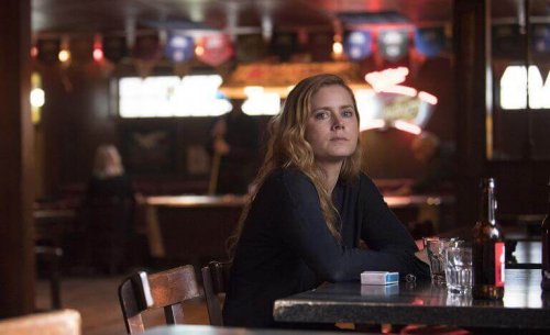 Camille, Hauptcharakter in der Serie WSharp Objects", sitzt allein in einer Bar.