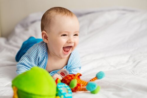 Ein Baby spielt mit Spielsachen und lacht.