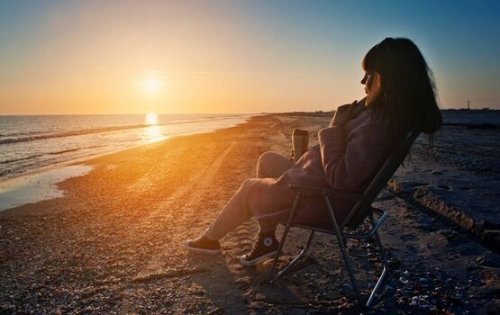 Digitale Diät: Eine Frau entspannt sich offline am Strand.