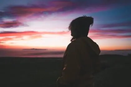 Frau schaut sich Sonnenaufgang an