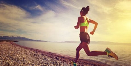 Eine Frau joggt am Strand.