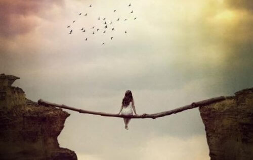 Eine Frau sitzt über einem Abgrund.