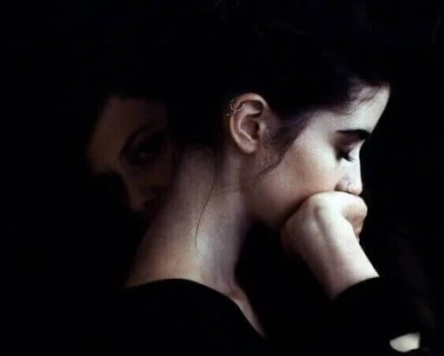 Frau mit zwei Gesichtern stützt sich auf ihre Hand