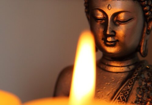 Eine Buddha-Statue vor einer Kerze