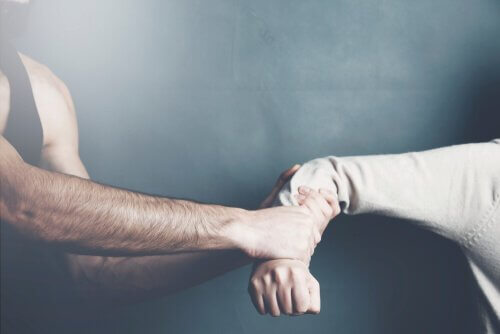 Ein Mann zerrt an einem Arm einer Frau, die sich sträubt.