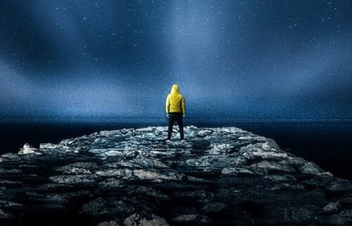 Ein Mann schaut in der Nacht in den Sternenhimmel.