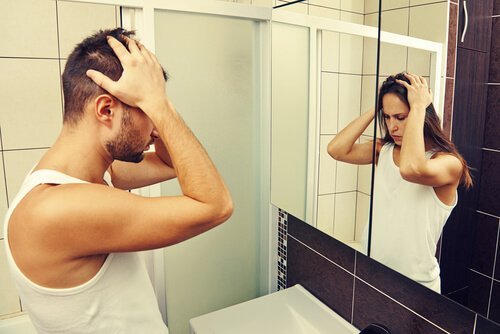 Mann sieht im Spiegel eine Frau