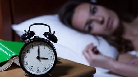 Frau liegt nachts wach im Bett