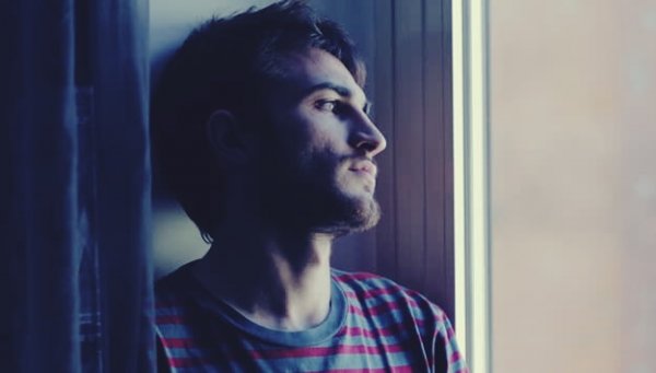 Mann mit Depressionen, der aus dem Fenster blickt