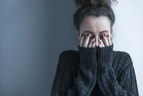 Depressive Frau, die sich die Augen zuhält